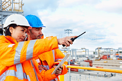 Buy stock photo Shot of two workers talking together over a digital tablet while standing on a commercial dock