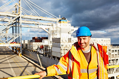 Buy stock photo Portrait of a man in workwear standing on an overhead walkway at a large commercial dock