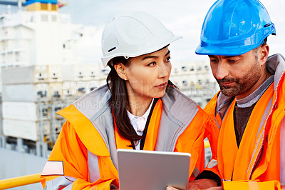 Buy stock photo Shot of two people talking over a digital tablet while standing on a large commercial dock