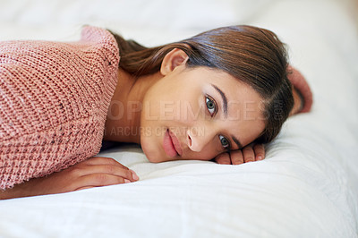 Buy stock photo Shot of a young woman lying on her bed