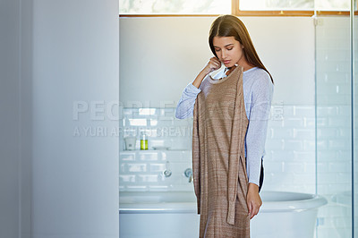 Buy stock photo Shot of a young woman standing in her bathroom trying on an outfit