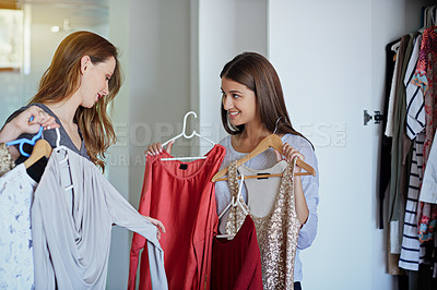 Buy stock photo Shot of a young woman helping her friend choose something to wear