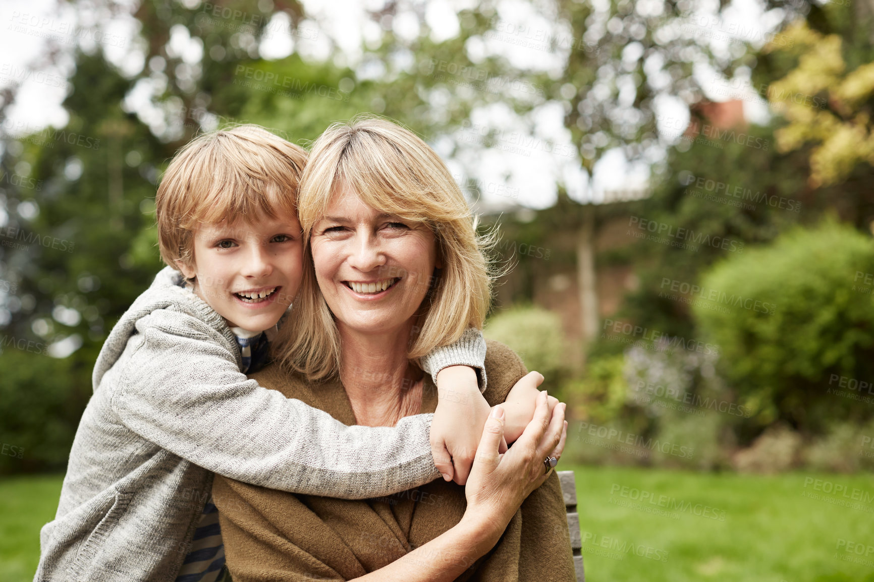 Buy stock photo Portrait of a grandmother and her young grandson hugging outside