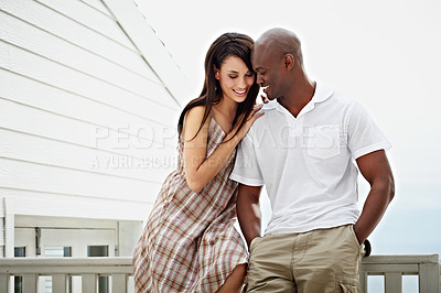 Buy stock photo Cropped shot of a young couple leaning on the railing of their balcony