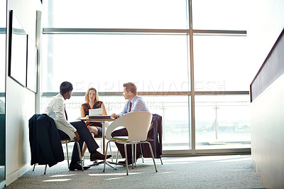 Buy stock photo Shot of three businesspeople meeting in the boardroom