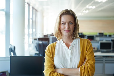 Buy stock photo Portrait of a businesswoman standing with her arms folded in the office
