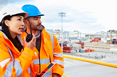 Buy stock photo Shot of two workers talking together over a digital tablet while standing on a commercial dock