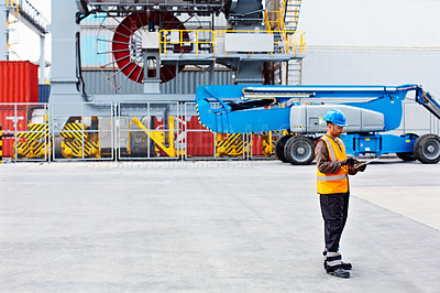 Buy stock photo Shot of man reading paperwork while standing on a large commercial dock