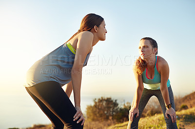 Buy stock photo Shot of two friends taking a breather while out for a run