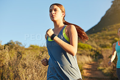 Buy stock photo Shot of two young woman out for a cross country run