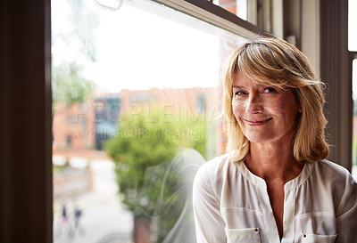 Buy stock photo Portrait of a smiling mature woman sitting by a window at home