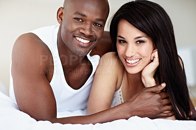 Buy stock photo Portrait of a smiling young couple lying in bed together