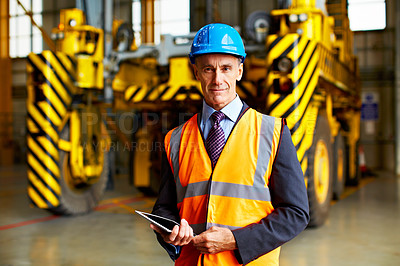 Buy stock photo Portrait of a mature man in workwear standing inside a large warehouse
