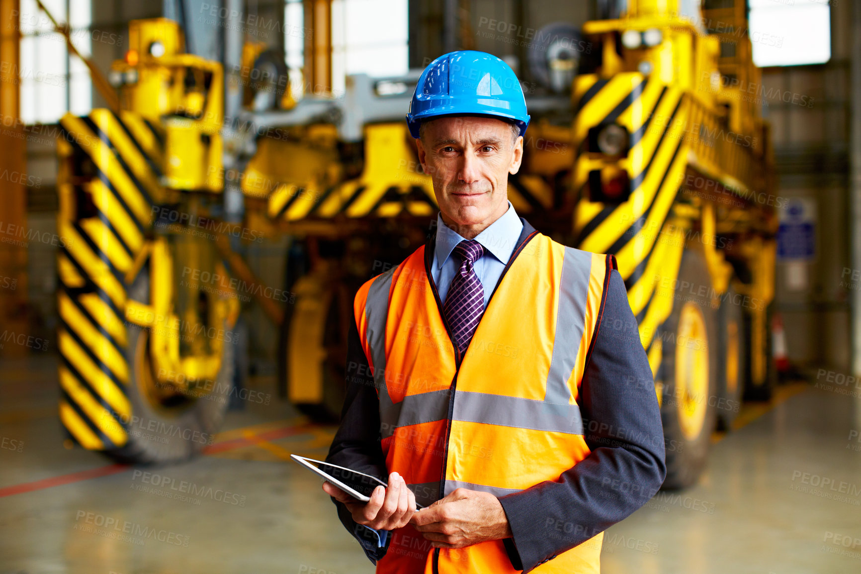 Buy stock photo Portrait of a mature man in workwear standing inside a large warehouse