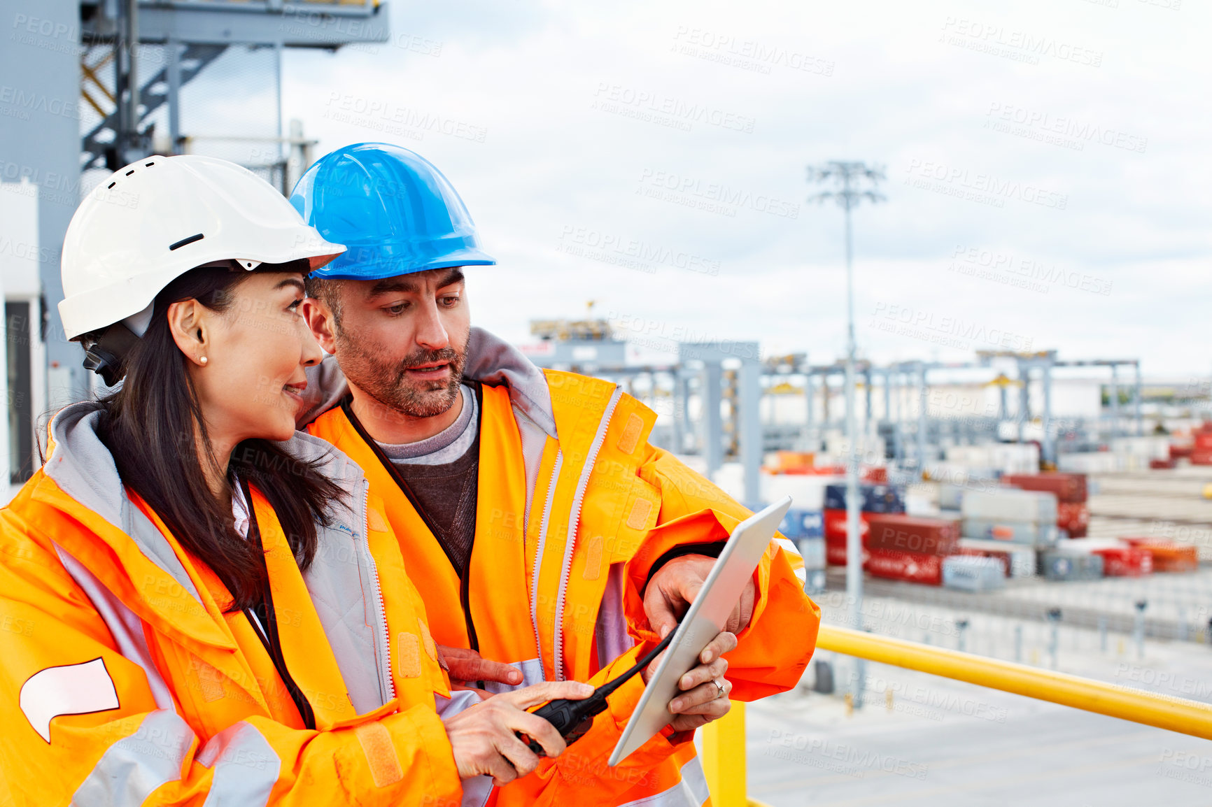 Buy stock photo Shot of two workers talking together over a digital tablet while standing on a commercial dock