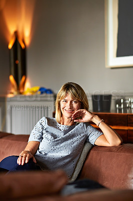 Buy stock photo Portrait of a mature woman relaxing on her living room sofa