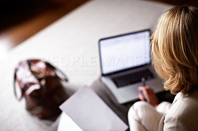 Buy stock photo Shot of a mature businesswoman going over some paperwork while sitting on her hotel bed