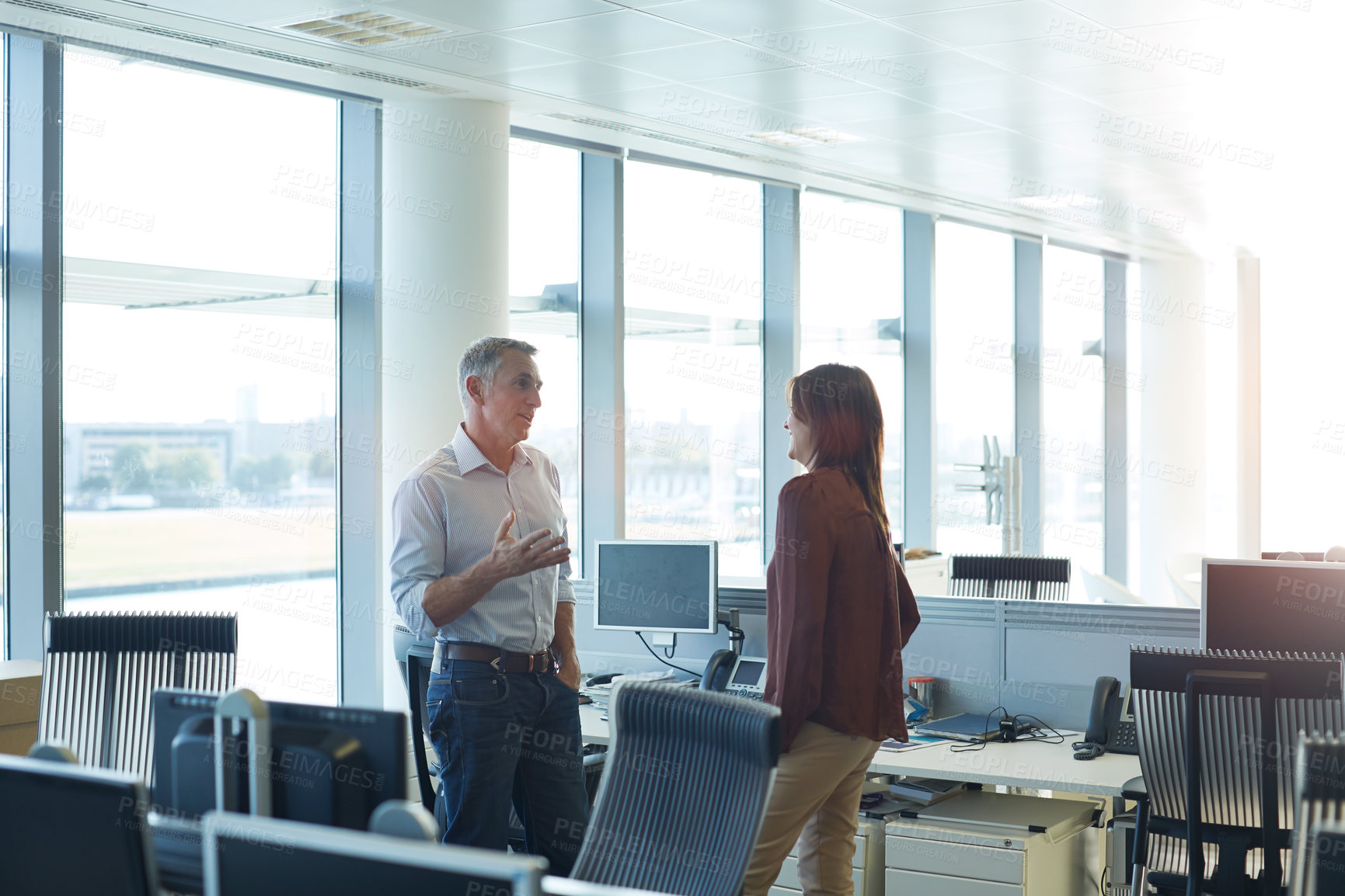Buy stock photo Shot of two people talking together while standing in an office