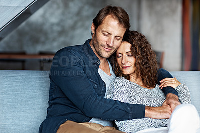 Buy stock photo Shot of an affectionate mature couple in their living room