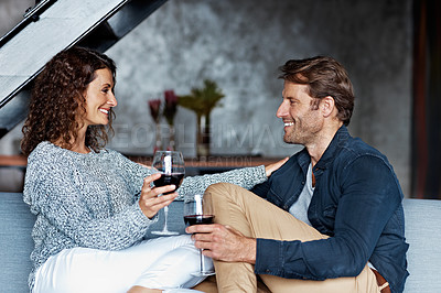 Buy stock photo Shot of a mature couple drinking wine while sitting on a sofa in their living room