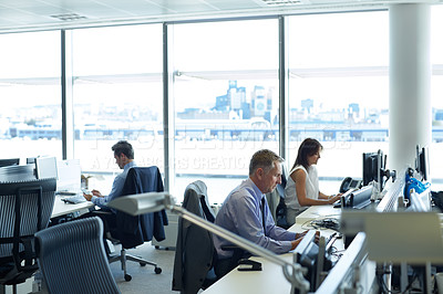 Buy stock photo Shot of businesspeople working at their desks in an office