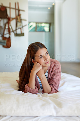 Buy stock photo Shot of a young woman lying on her bed