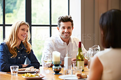 Buy stock photo Shot of a group of friends enjoying a home-cooked dinner together