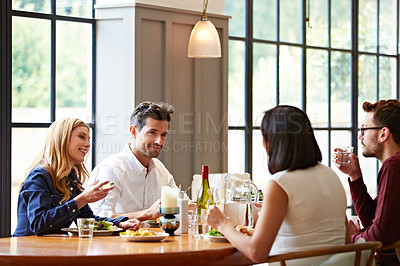 Buy stock photo Shot of a group of friends enjoying a home-cooked dinner together