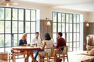 Buy stock photo Shot of a group of friends enjoying a home-cooked dinner together