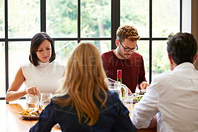 Buy stock photo Shot of a group of friends enjoying a home-cooked dinner together
