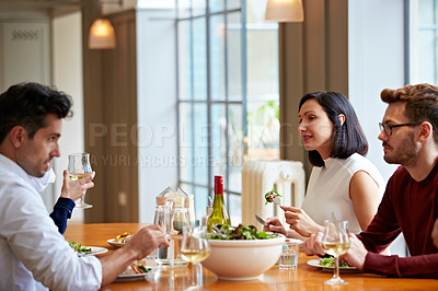 Buy stock photo Shot of a group of friends enjoying a home-cooked dinner together