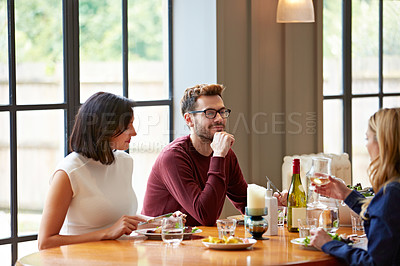 Buy stock photo Shot of a group of friends enjoying a home-cooked dinner together