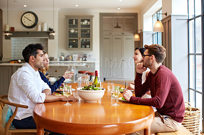 Buy stock photo Shot of a group of friends enjoying a home-cooked dinner together