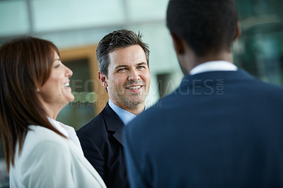 Buy stock photo Shot of businesspeople talking together in the lobby of an office building