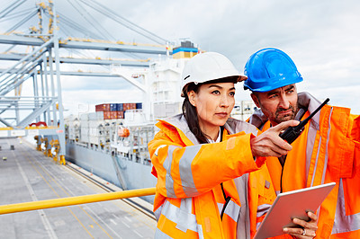 Buy stock photo Shot of two workers talking together over a digital tablet while standing on a commercial dock