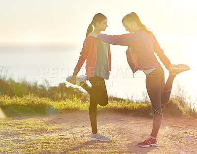 Buy stock photo Shot of two young friends stretching before a trail run