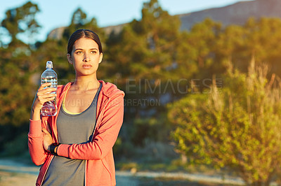 Buy stock photo Portrait of a young woman taking a water break while out for a cross country run