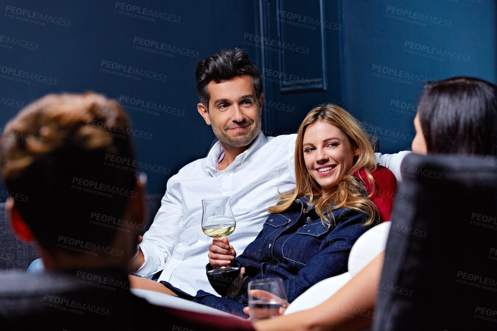 Buy stock photo Shot of a group of friends enjoying a night in together at home