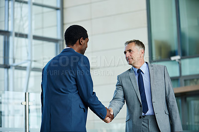 Buy stock photo Shot of of two businessmen shaking hands in the lobby of an office building