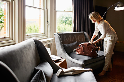 Buy stock photo Shot of a mature woman unpacking at home after a trip