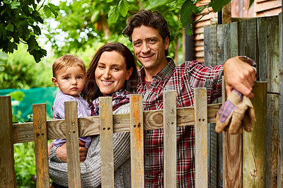 Buy stock photo Portrait of a couple with their baby girl standing in their organic garden