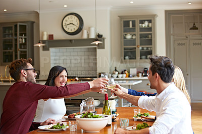 Buy stock photo Shot of a group of friends toasting together over dinner