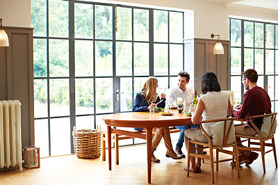 Buy stock photo Shot of a group of friends enjoying a home-cooked dinner together