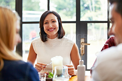 Buy stock photo Shot of a group of friends talking together while enjoying a home-cooked dinner