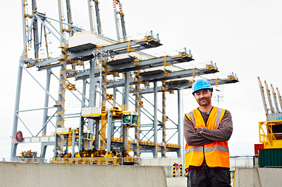 Buy stock photo Portrait of a young man in workwear standing outside on a large commercial dock