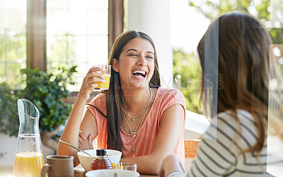 Buy stock photo Shot of two friends eating breakfast together on a balcony