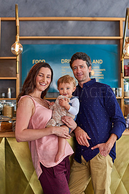 Buy stock photo Portrait of smiling couple and their little girl standing in their bakery