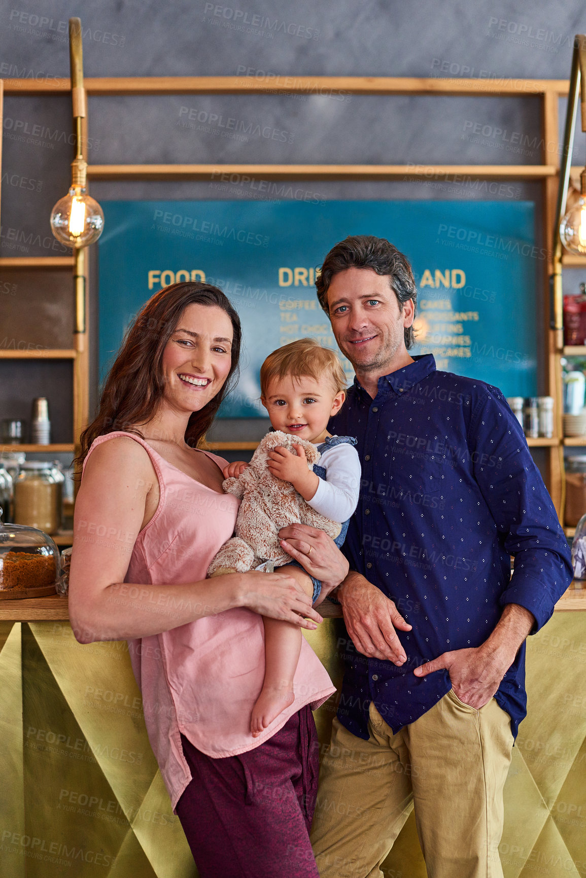 Buy stock photo Family, smile and coffee shop with small business owners, welcome and baby with stuffed animal. Child, mom and pop at cafe with happy partner, entrepreneur parents and hospitality startup portrait