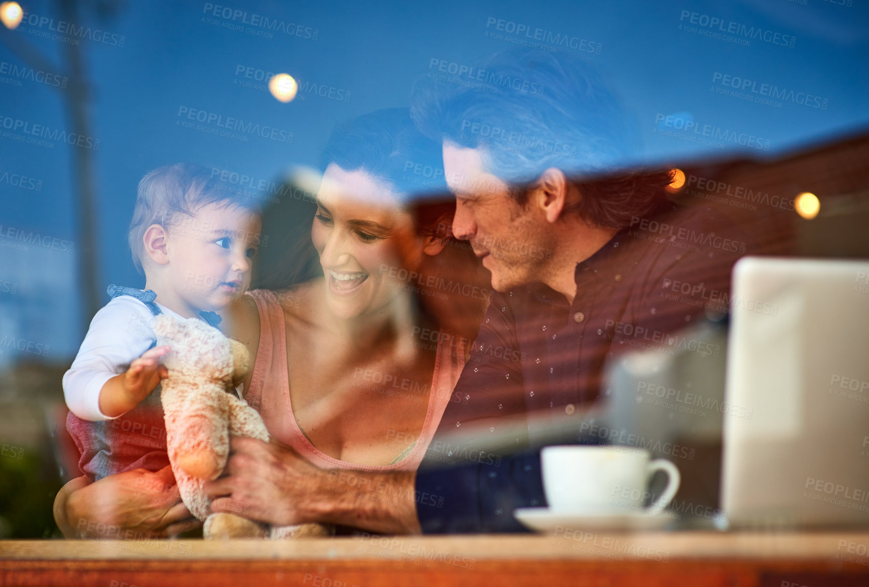 Buy stock photo Shot of a loving couple with their baby daughter sitting in a cafe