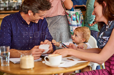 Buy stock photo Shot of a couple and their baby daughter sitting at a table in a cafe